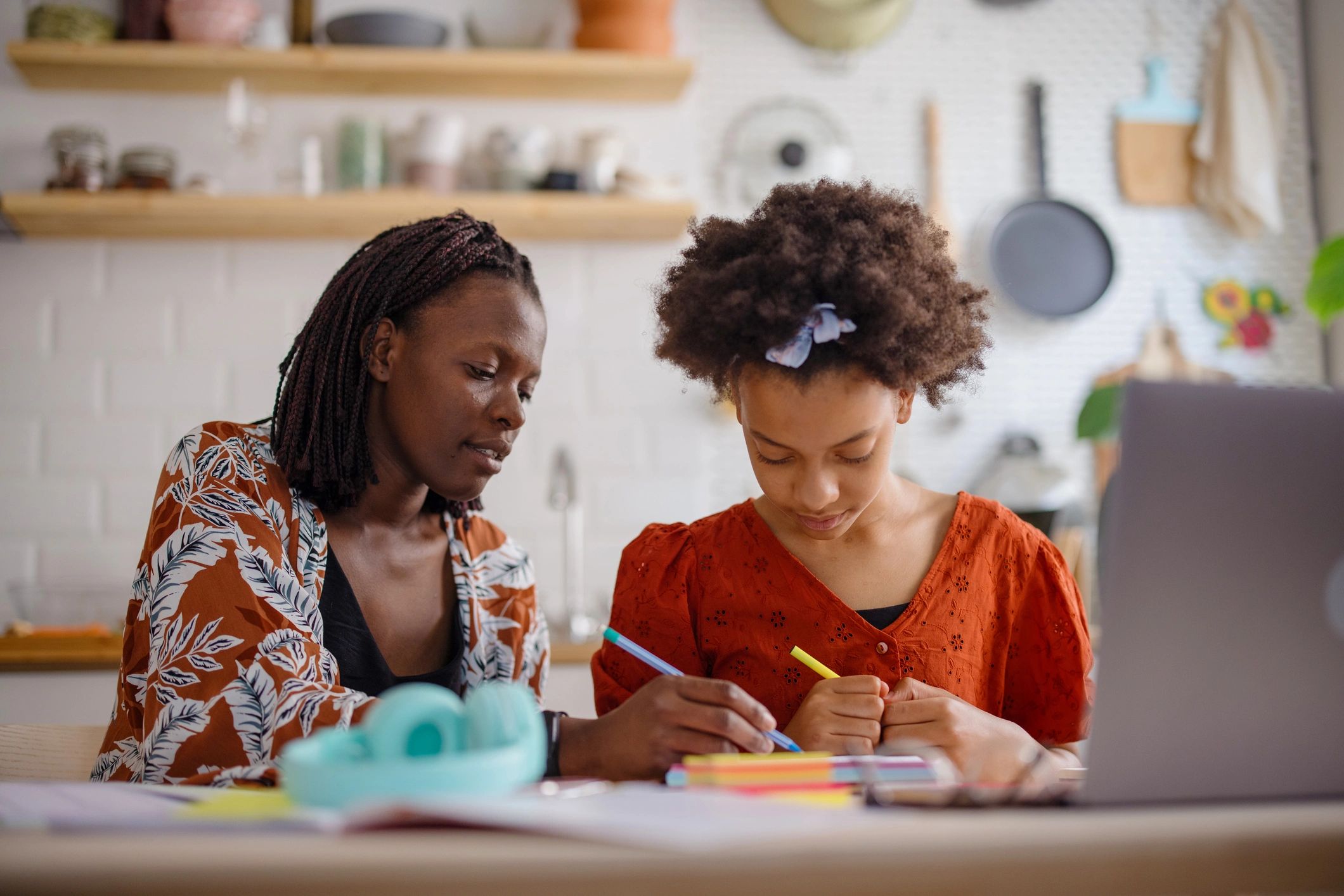 Parent and child working together at a laptop at home in a calm learning space