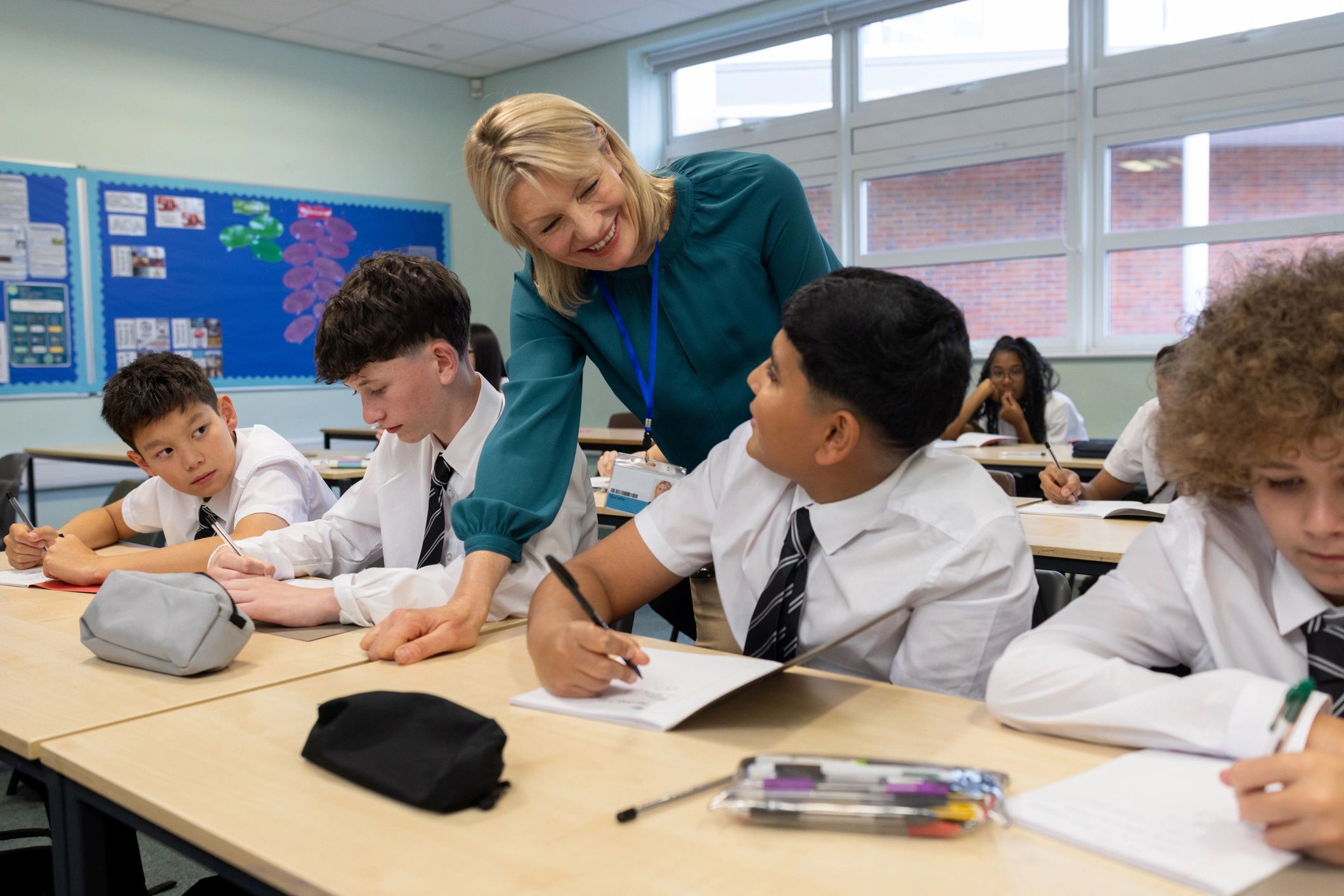 Teacher supporting pupils in a bright classroom